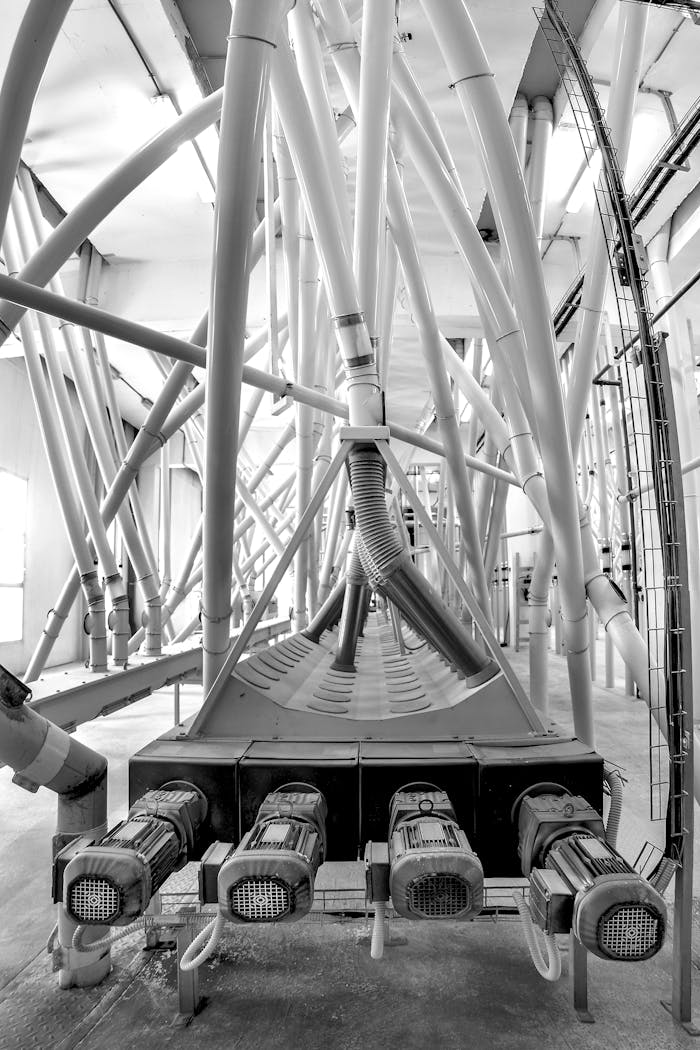 Black and white image of intricate pipe networks in an industrial facility.